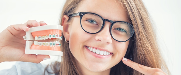 young lady showing braces model smiling